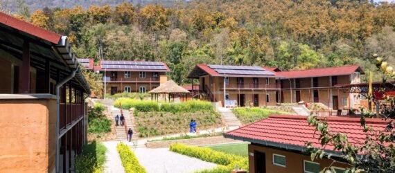 rammed earth school buildings topped with solar panels