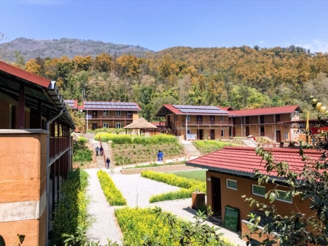 rammed earth school buildings topped with solar panels