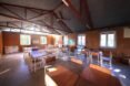 classroom with several wood desks and rammed earth walls
