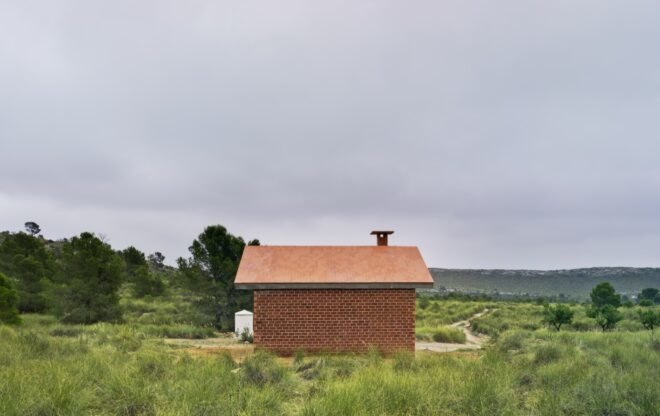 small brick house surrounded by grass