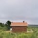small brick house surrounded by grass