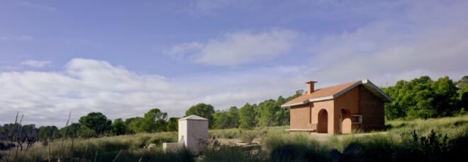 small brick home with gabled roof on grassy lot