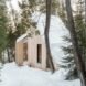 wood cabin with sloped roof covered in snow