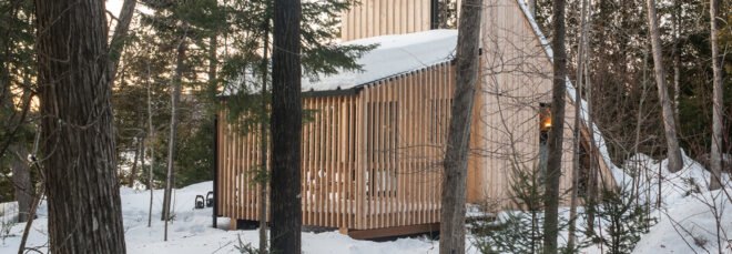 wood A-frame micro home in snowy forest