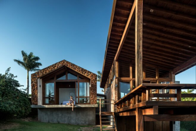 stone home with pitched roof and wooden deck