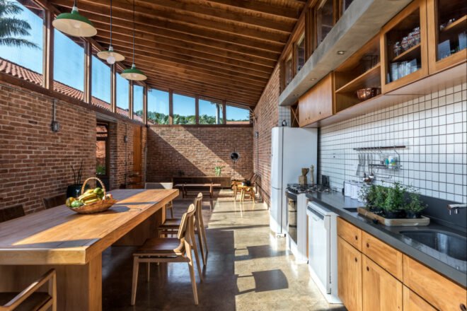 open-plan space with wood furnishings in living room followed by a large wood dining set in front of the kitchen