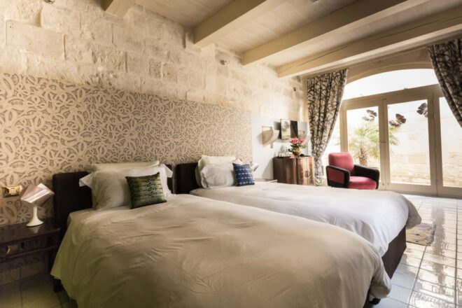spacious guest room with two beds with gray covers