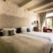 spacious guest room with two beds with gray covers