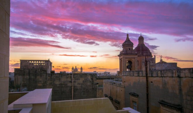 view of city at sunset from rooftop terrace