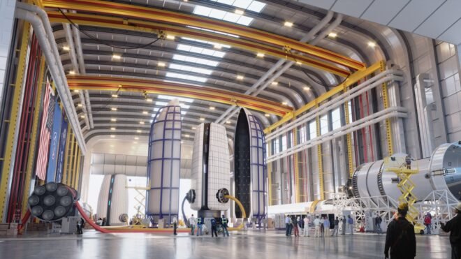 rendering of people building living pods inside a workshop