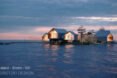 rendering of a series of gabled wood and glass cabins on an island