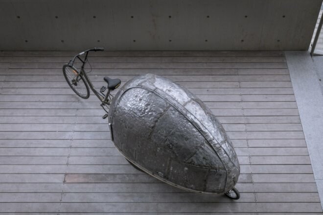 aerial view of metal contraption on wheels in the shape of a beetle