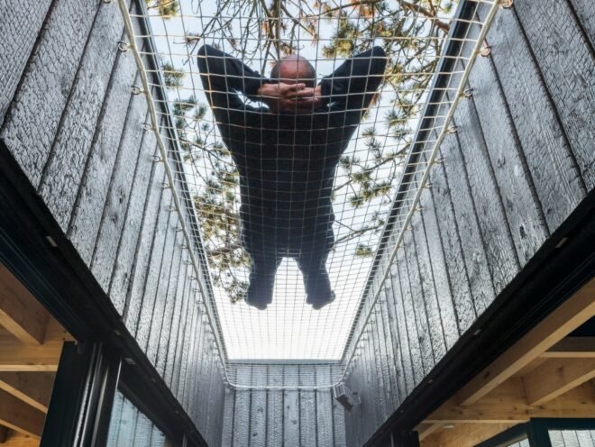 man sleeping on hammock hung between two walls