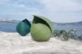 blue and green seashell sculptures on a rock by the sea