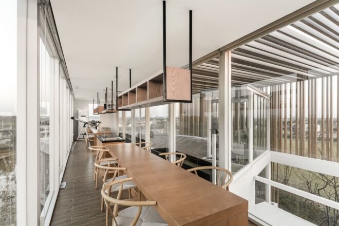 long wood tables with several chairs in narrow room