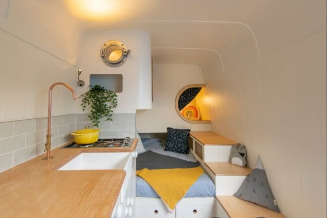 camper van interior with day bed and small kitchen