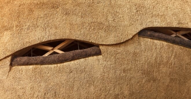 close-up of wood structure with small openings for bird watching