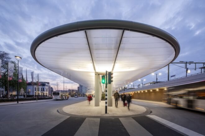 bus station with curved awning lit up at night