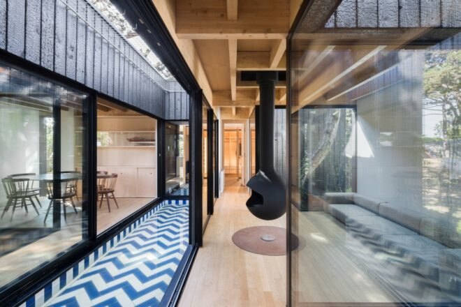 living area with glass walls and large black fireplace