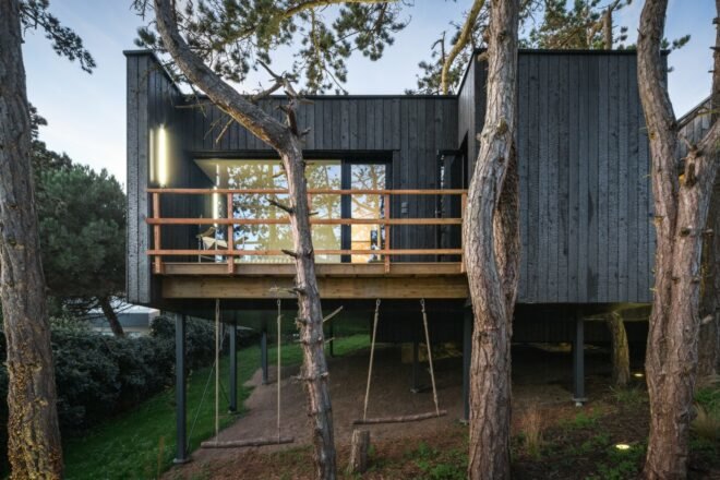 black timber home behind wooden walkway