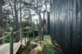 long wood walkway leading to black timber home