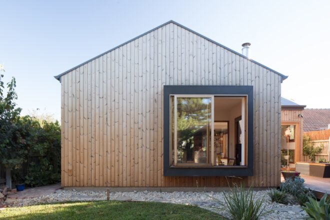 wood home with gabled roof and large square window
