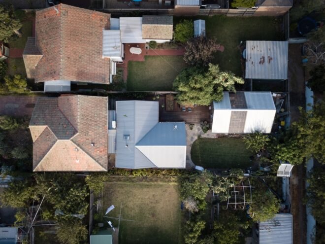 aerial view of cottage with wood extension and backyard with wood deck