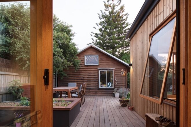 wood deck leading to wood building with gabled roof