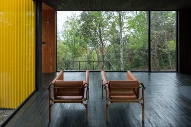 two chairs a re placed infant of a floor to ceiling window