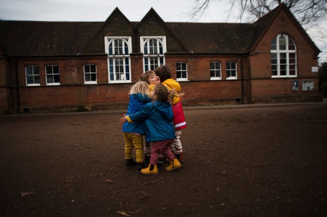 group of kids in raincoats hugging