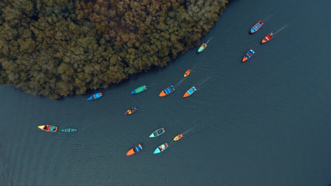 aerial view of several colorful fishing boats on the water
