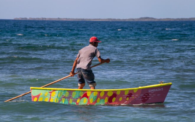 person rowing colorful boat on water