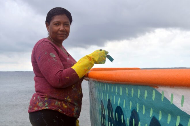 person painting a colorful boat