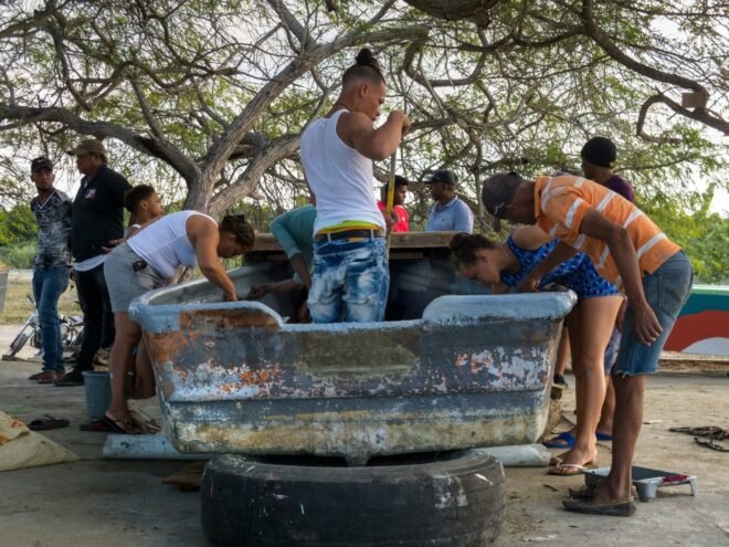 group of people painting a boat