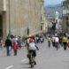 people biking and walking on a road near buildings