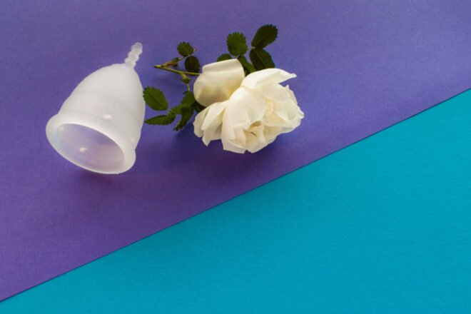 menstrual cup and a flower on blue and purple background