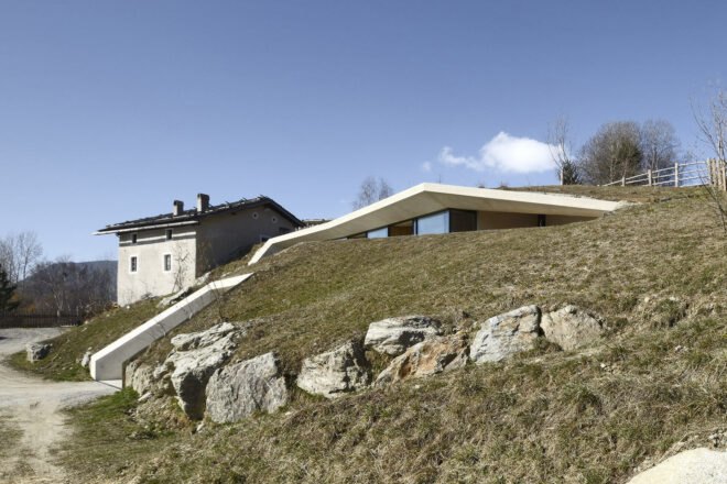 white concrete home with green roof