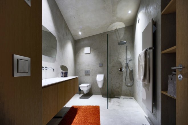 gray concrete bathroom with modern toilet and glass shower