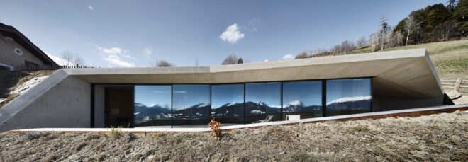 white concrete home built into a hill