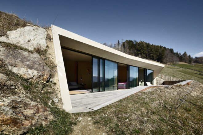 white concrete home built into a hill