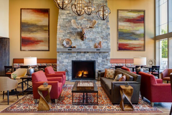 lobby with red and brown seating and large stone fireplace