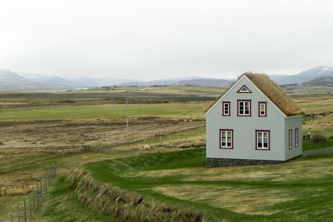 gray home with gabled green roof