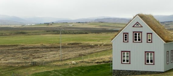 gray home with gabled green roof