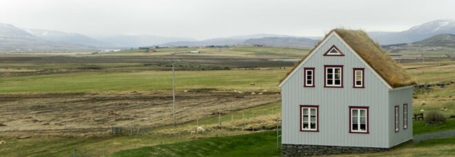 gray home with gabled green roof