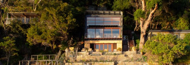 home with glass facade built on shoreline