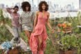 three models in colorful spring outfits in a garden