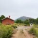 small brick home with gabled roof on grassy lot