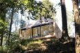 wood cabin perched on cliff in a forest