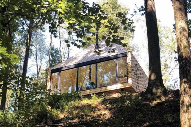 wood cabin perched on cliff in a forest