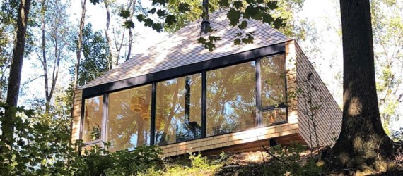wood cabin perched on cliff in a forest